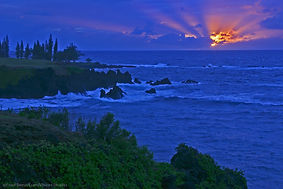 The sun rises through a cloudy horizon of the Pacific Ocean from Maka Alae Point on the Hawaiian island of Maui