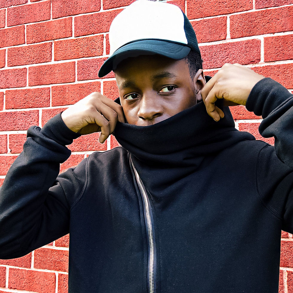 Young man pulling up hoodie collar, wearing a cap