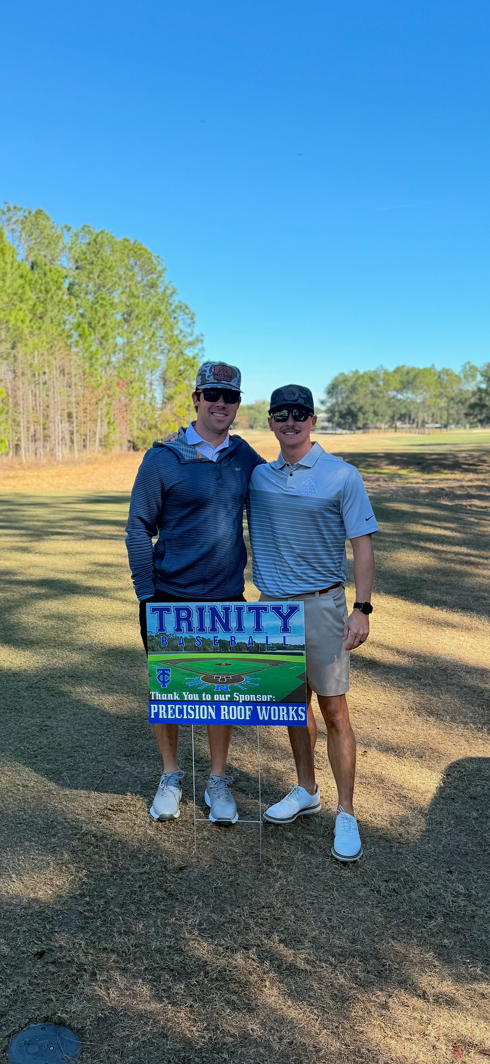 Precision Roof Works employees holding a Trinity Golf Classic sign on a golf course for fundraiser