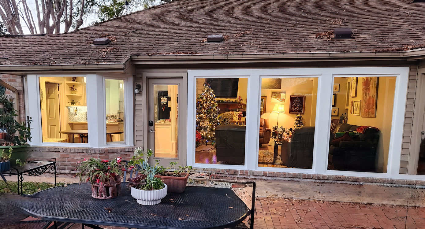 Rear view of a suburban home with three new double-hung windows and clean exterior trim.