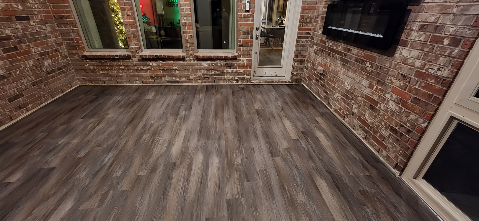 Newly remodeled patio with wood floor and brick wall, home projects in Cypress