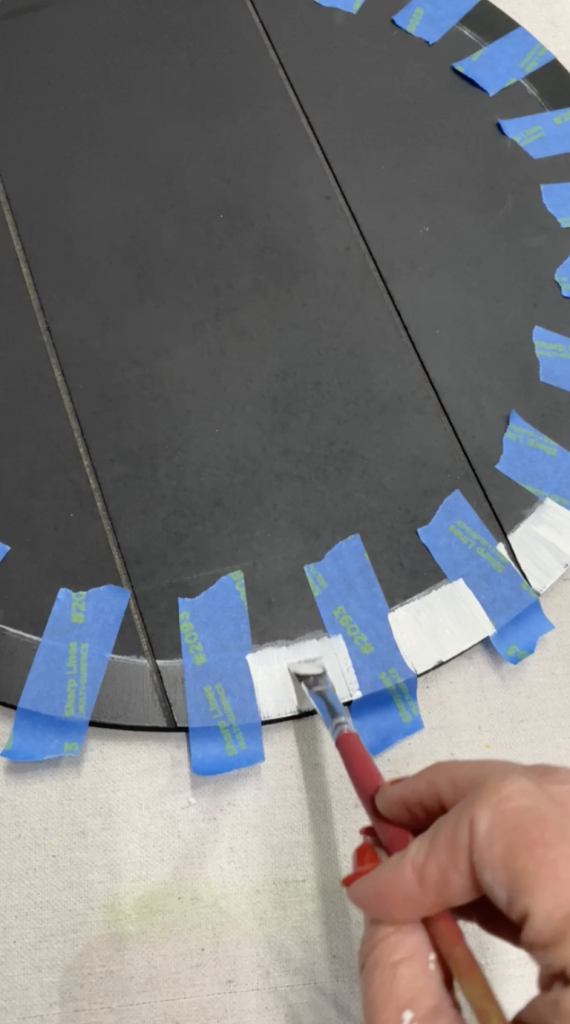 Tracey's Fancy creating a pattern with painter's tape and Dixie Belle Paint on a DIY door hanger.