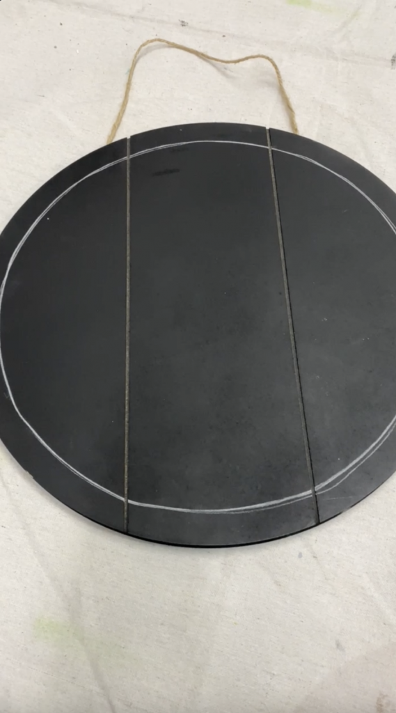 Circle drawn by Tracey's Fancy on a black door hanger with chalk