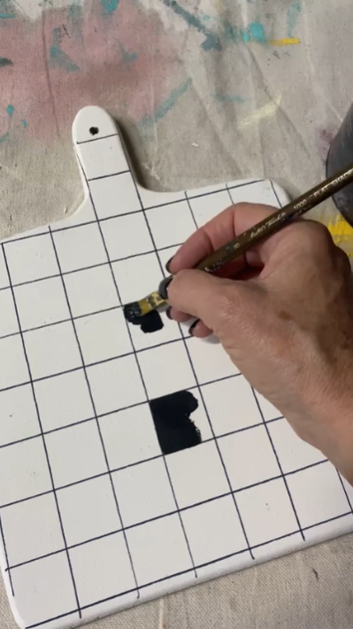 Applying onyx paint onto Enchanting Bread Boards to create pattern