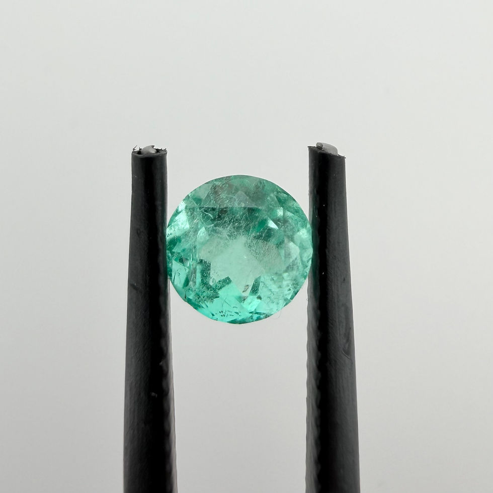 Thumbnail: Round Muzo emerald held in tweezers, showing blue-green color and natural inclusions.
