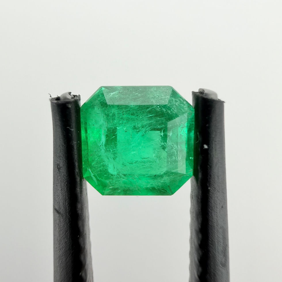 Thumbnail: 0.76 ct Muzo Colombian emerald in tweezers, emerald cut step facets, natural inclusions visible