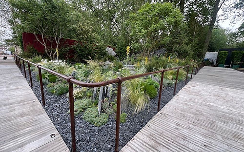 Bespoke weathered ball-standard handrail by Kite Group integrated into the Bridge to 2030 Garden design at the RHS Chelsea Flower Show.