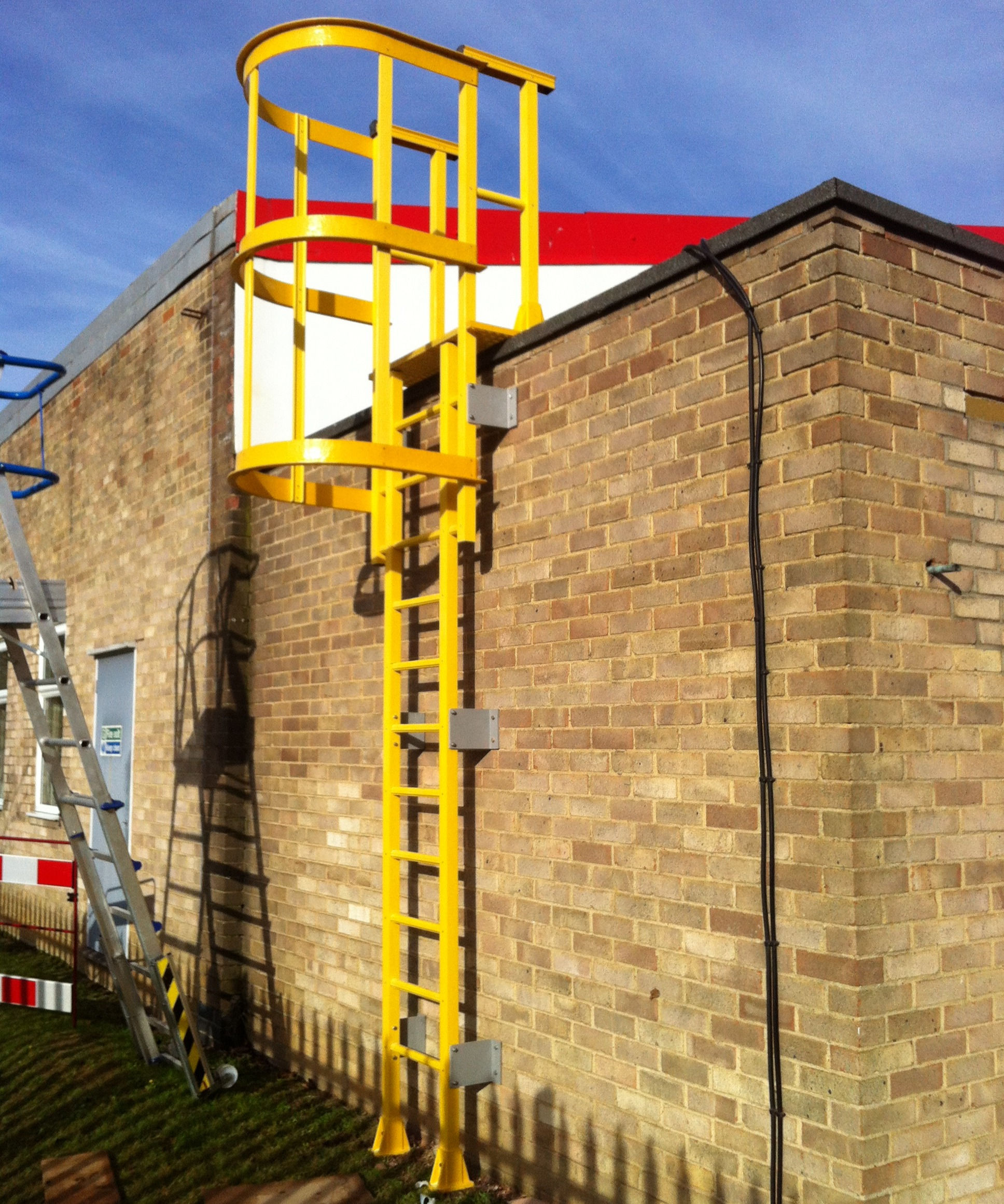 yellow Fibreglass GRP Access Ladder in-front of a brick building