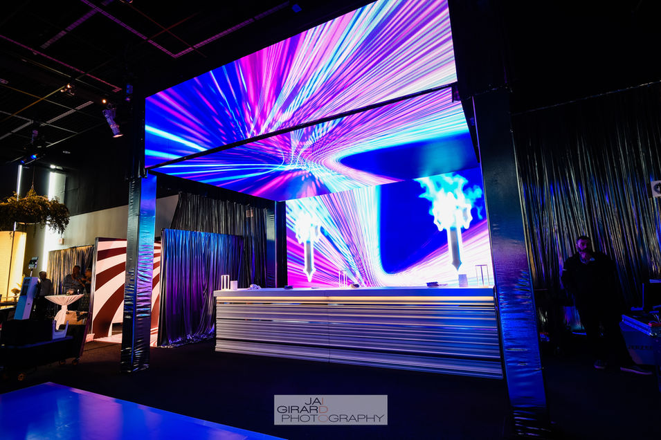 White Bar with LED wall and cantilevered ceiling with custom content.