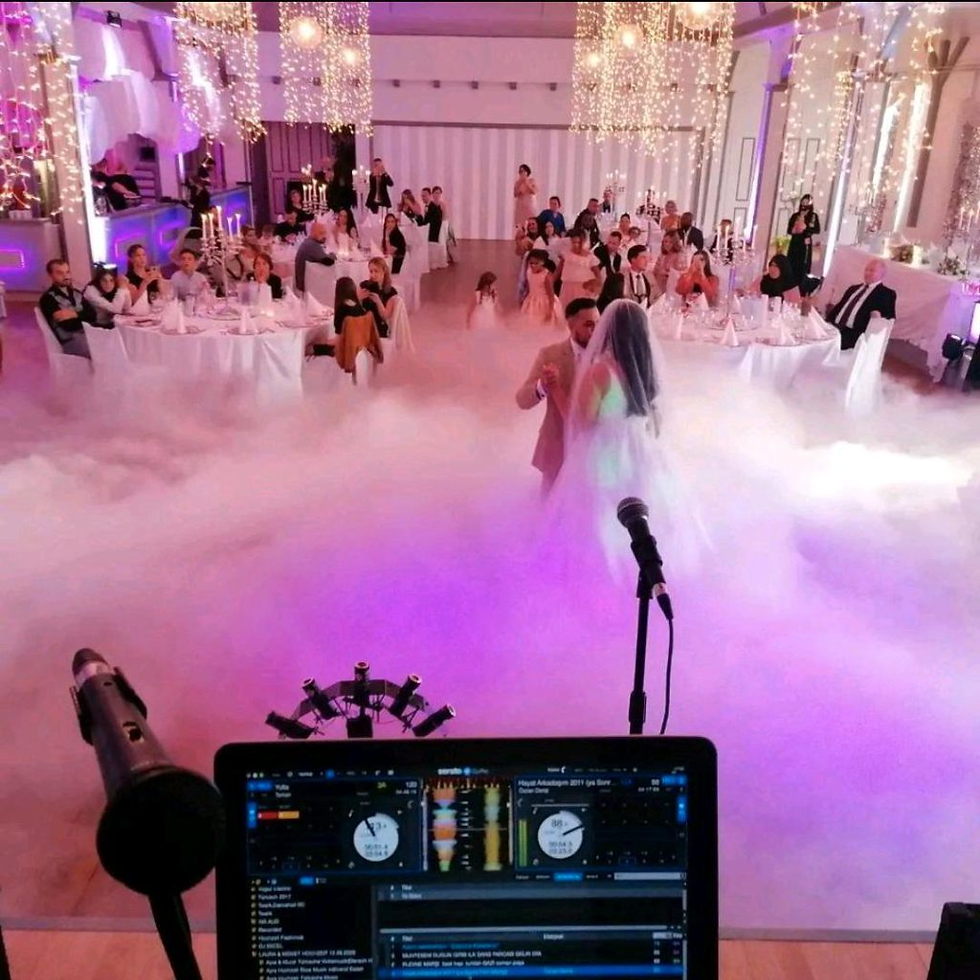 Hochzeitstanz eines Brautpaares im Nebel, Blick vom DJ-Pult mit Mikrofon im Vordergrund