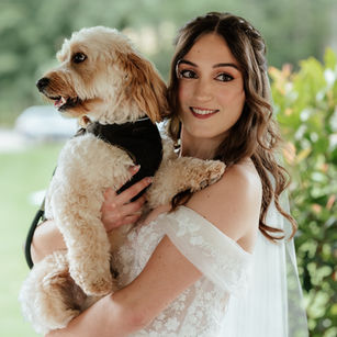 Brunette bride holding her dog wearing polished bridal makeup