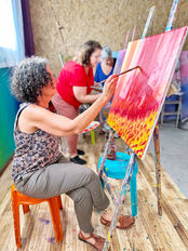 אישה יושבת ומציירת על קנבס