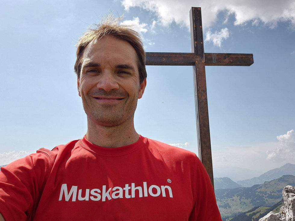 Peter mit einem Gipfelkreuz im Hintergrund