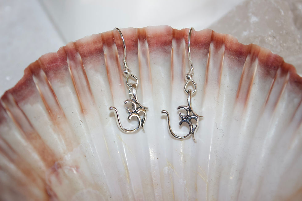 Om symbol sterling silver 925 ALE stamped earrings pictured on a seashell