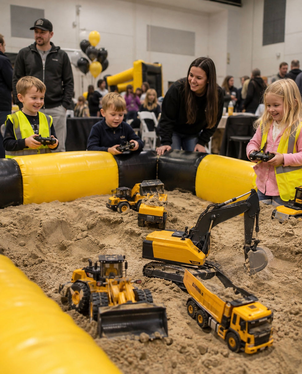 Miami kids construction birthday setup with manual construction vehicles and RC trucks sharing the play-sand activity area.