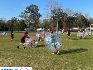 Children playing bubble soccer at a summer camp event in Atlanta