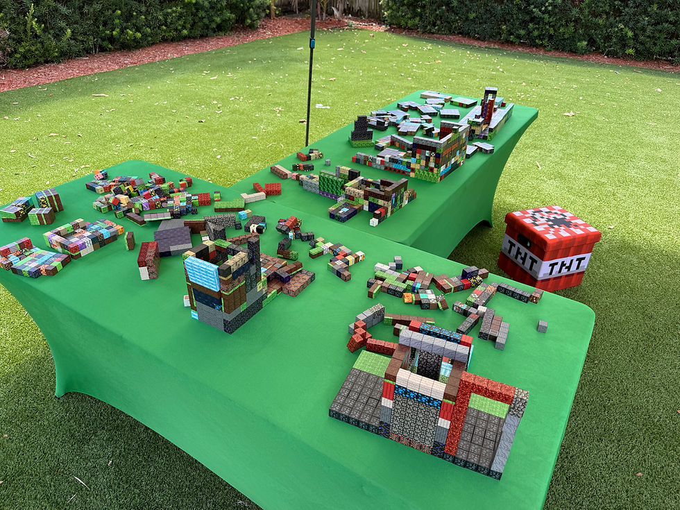 Minecraft-inspired tabletop building activity with small interlocking pieces and assembled structures arranged for a creative party.