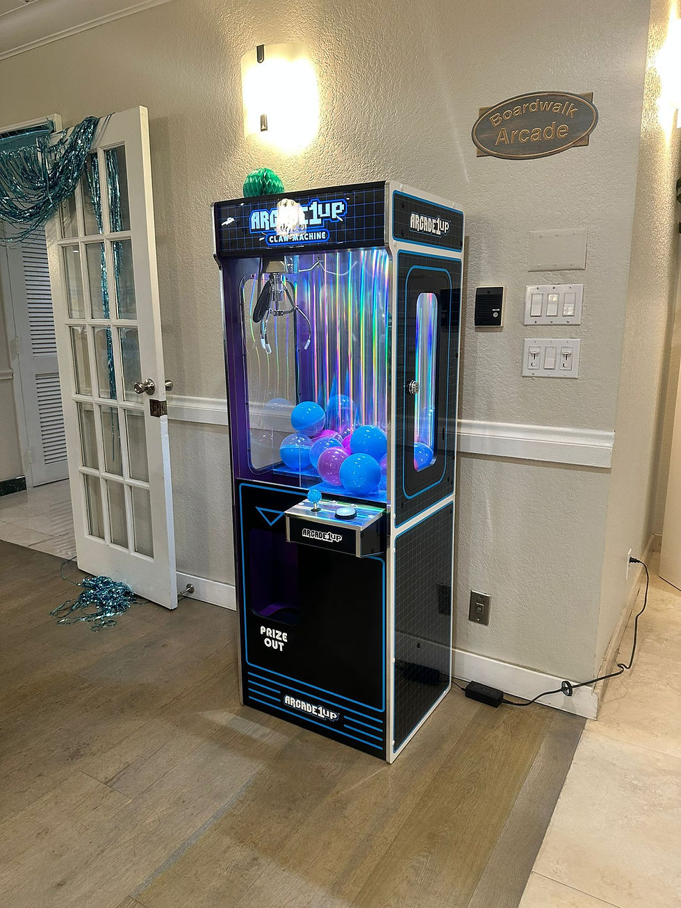 Black claw machine with colorful prize balls at a venue