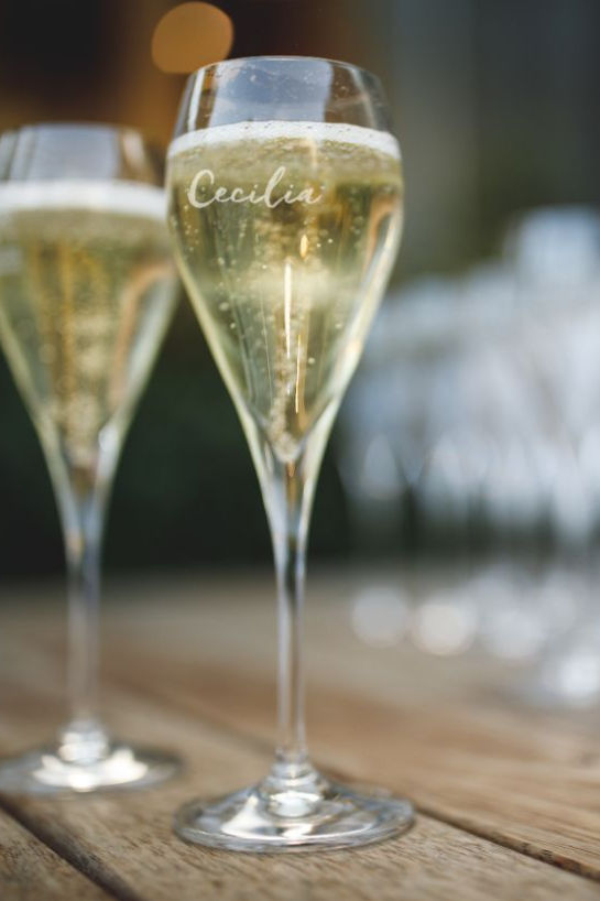 Two filled up glasses of sparkling wine.