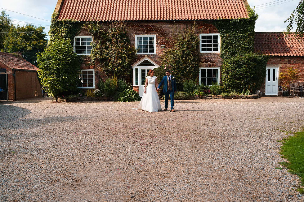 bride and groom walking in front of howard court wedding venue