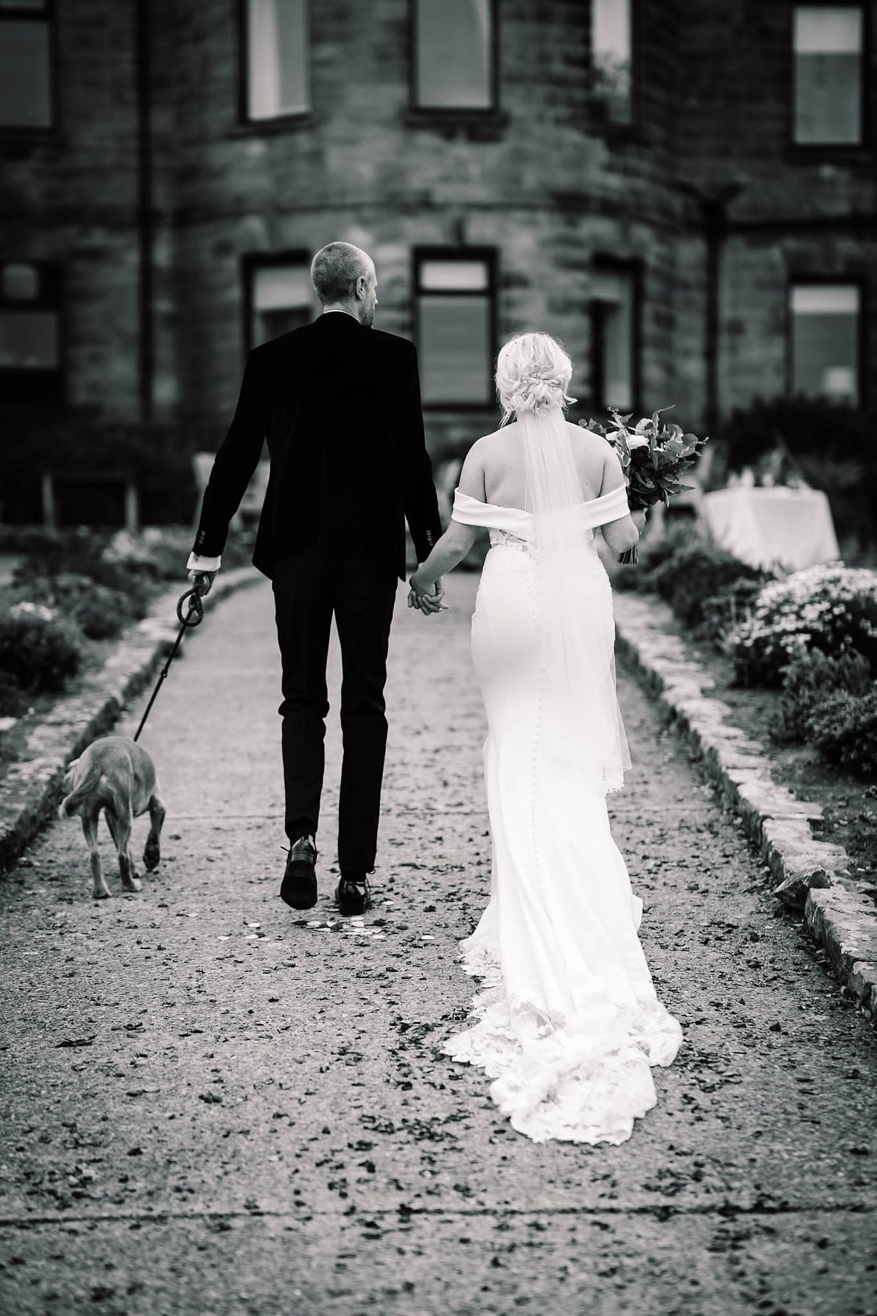 black and white bride and groom walking photo at grand villa heights wedding venue