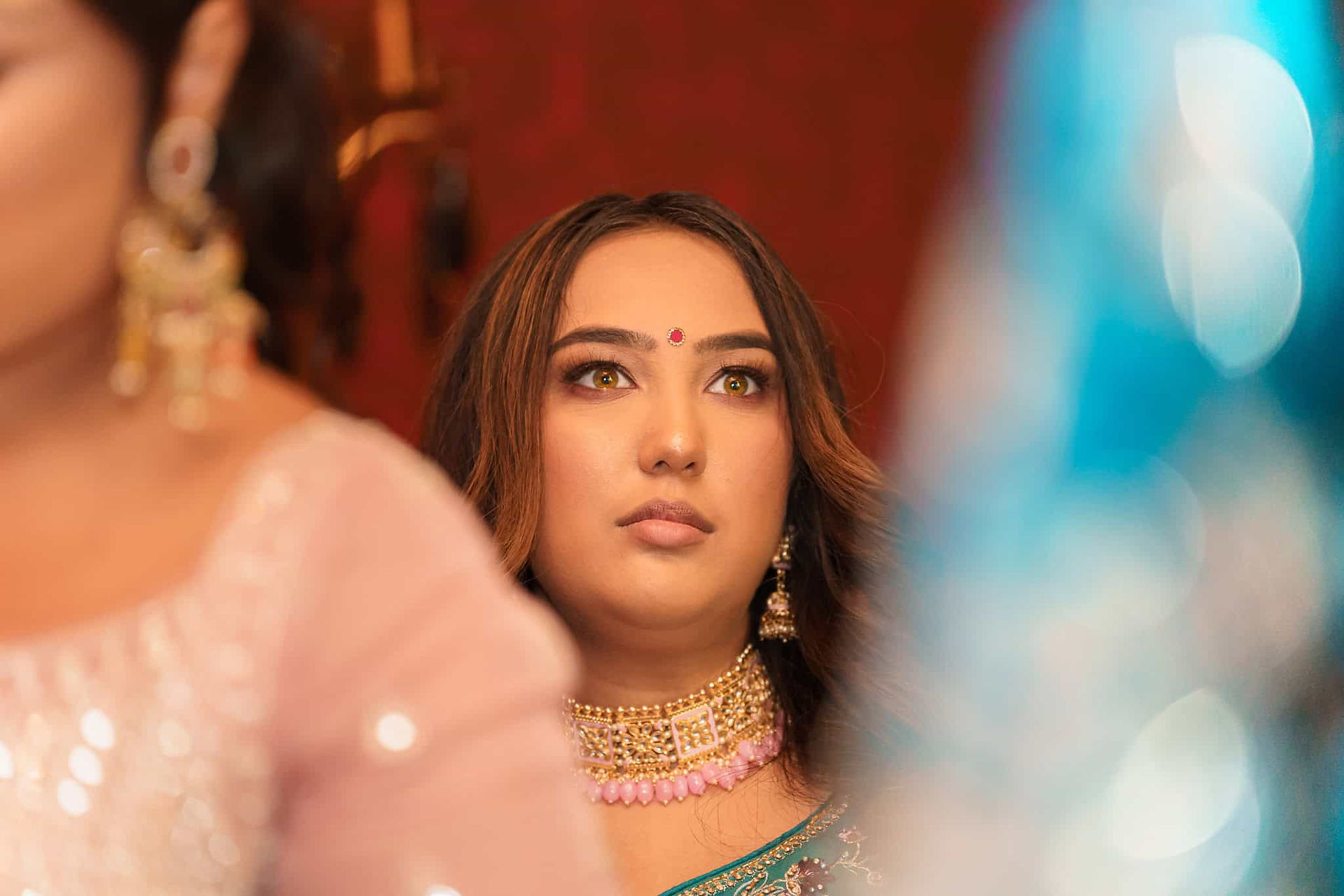 bridesmaid in traditional indian wedding attire during bridal prep at langley castle