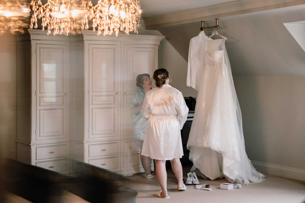 bride and bridesmaid inspecting wedding dress