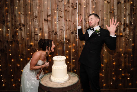 bride and groom cutting cake and laughing
