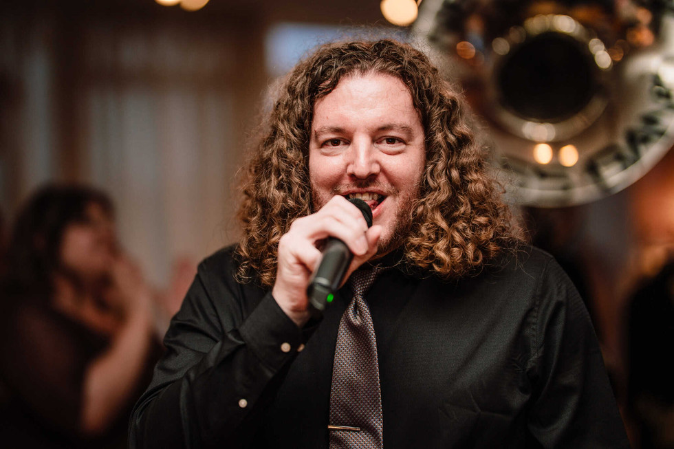 groom singing as he enters reception with brass band