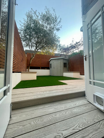 Small Battersea, London garden with premium Millboard limed oak composite decking  and custom benches for stylish, functional outdoor living