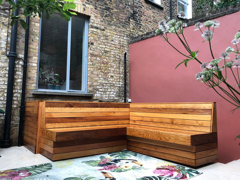 A custom built cedar bench in Clerkenwell, London. The bench is in an L shape, optimising space above the stairs