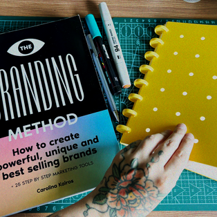 un libro de branding acompañado de una libreta de notas amarilla