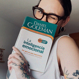 Girl with tattoos and a book of emotional intelligence
