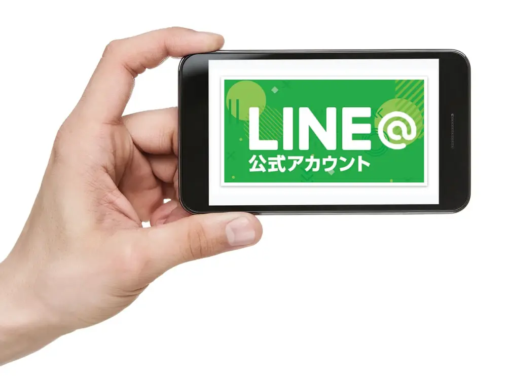 スマートフォンを手にしながら、公式LINEを見ている