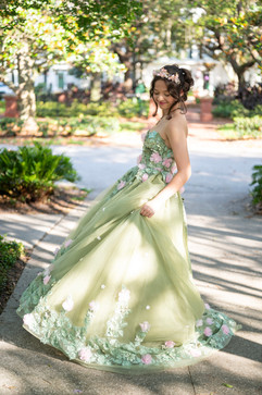 Girl in green ballgown twirling her dress