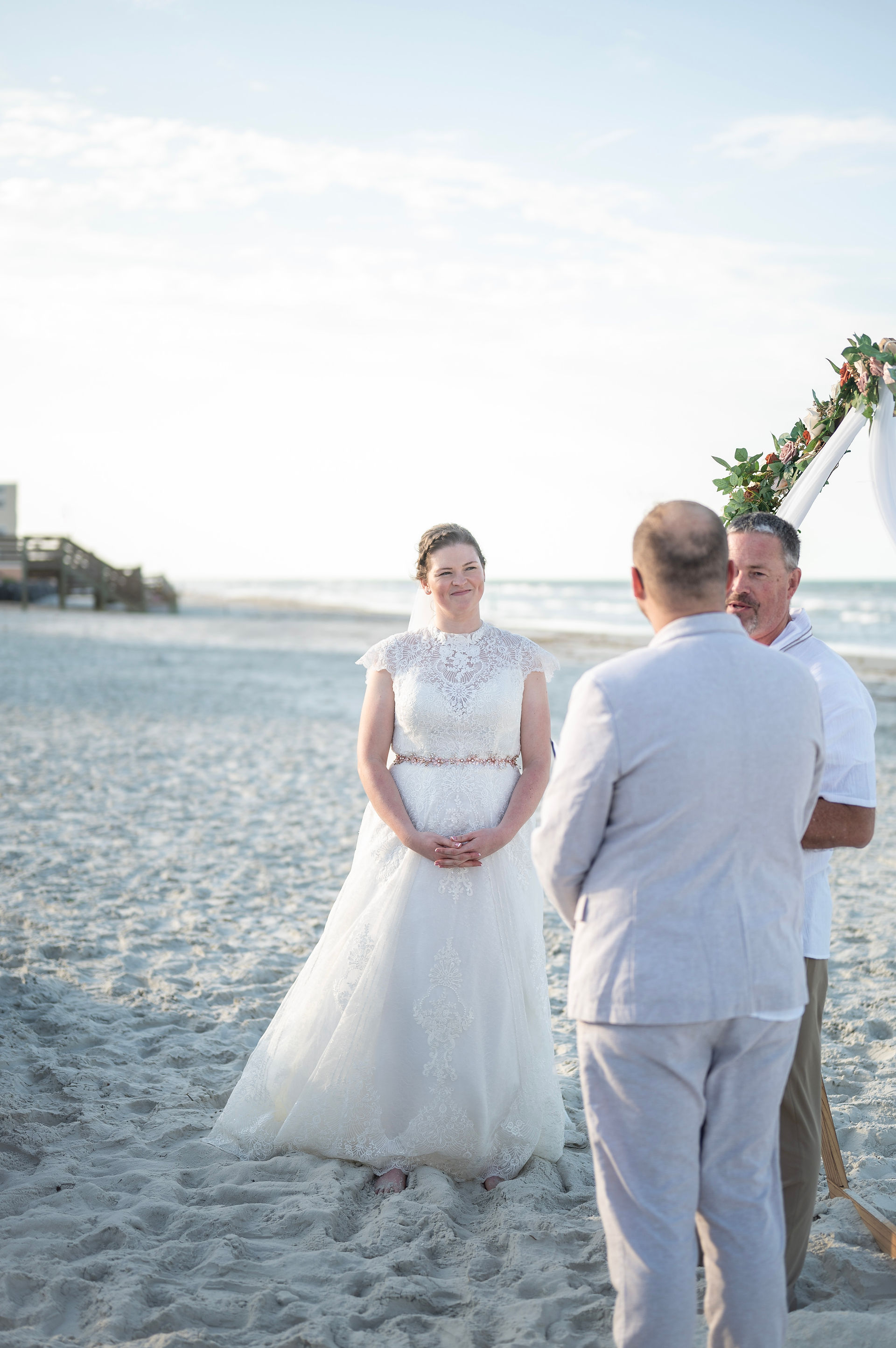 Bride looking at her groom during the wedding ceremony on New Smyrna Beach, Florida