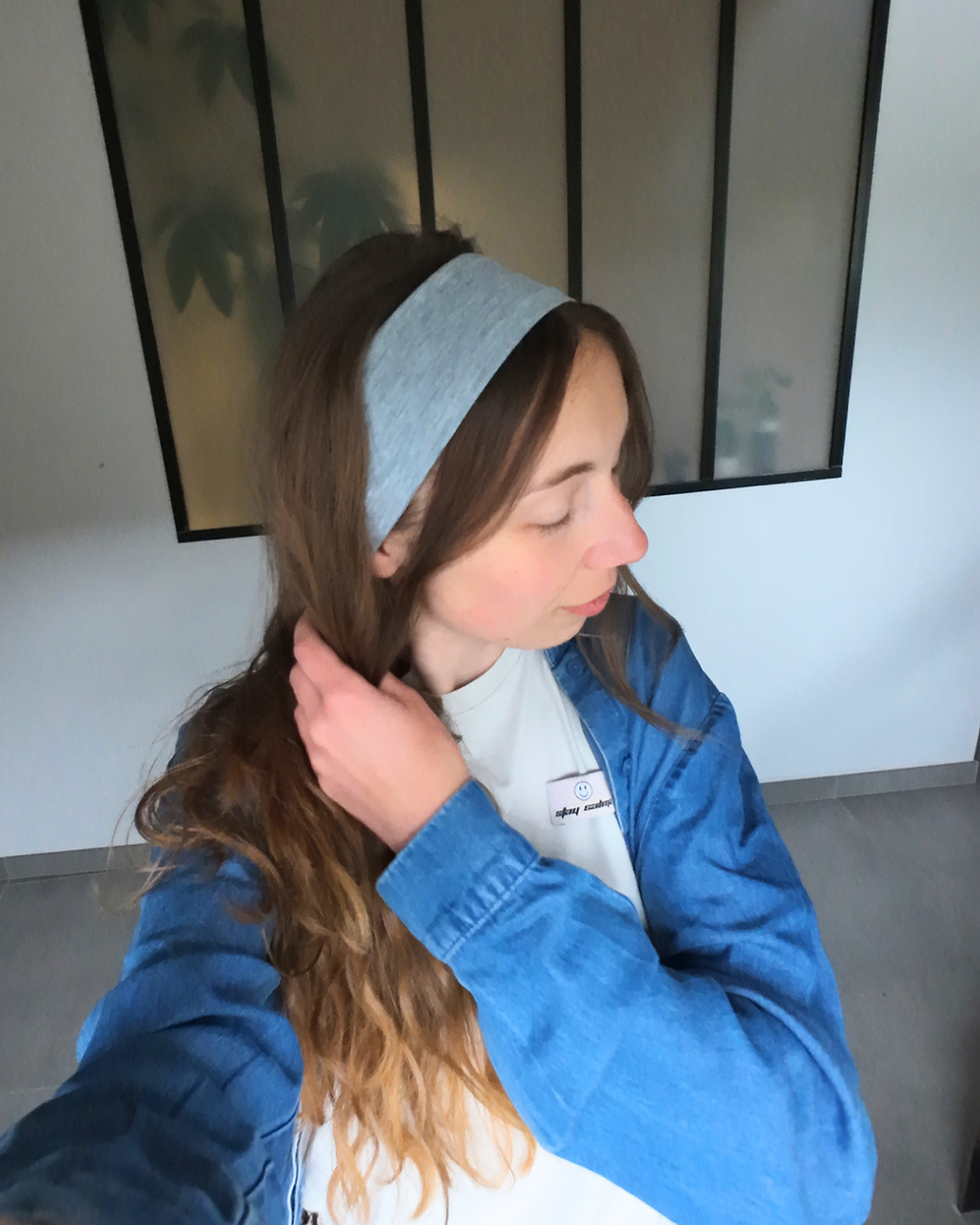 Femme portant un bandeau gris dans les cheveux et une chemise en jeans