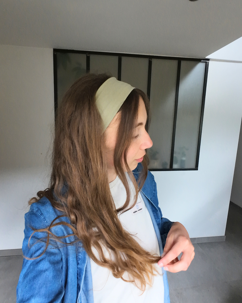 Femme de profil portant un bandeau kaki dans les cheveux et une chemise en jeans