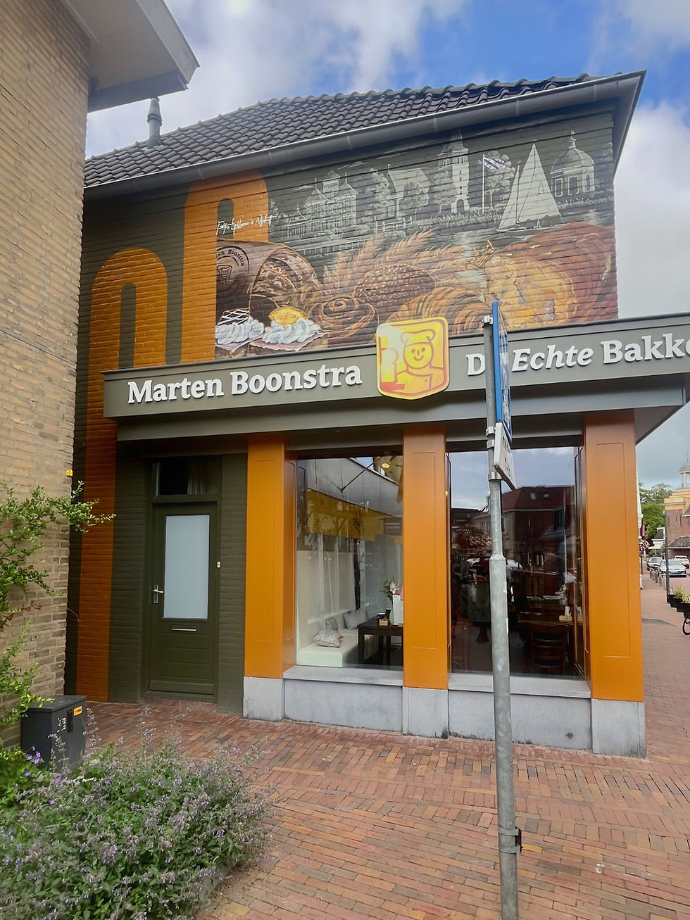 Een muurschildering op de gevel van Bakkerij Marten Boonstra in Akkrum presenteert lokale iconen en elementen van de bakkerij in een muurschildering.