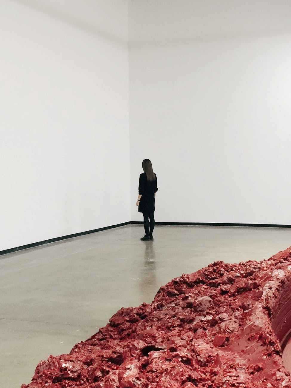 woman wearing black elbow sleeved top standing on gray concrete floor