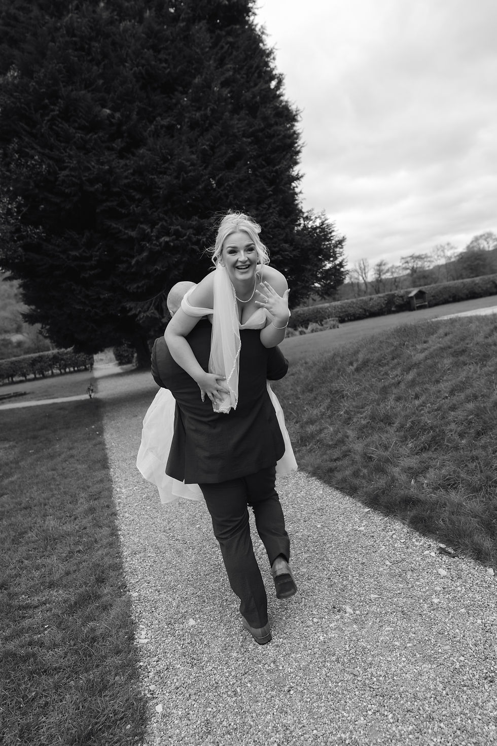 groom carrying bride in a piggyback on the grounds at Hackness Grange Yorkshire candid wedding photography