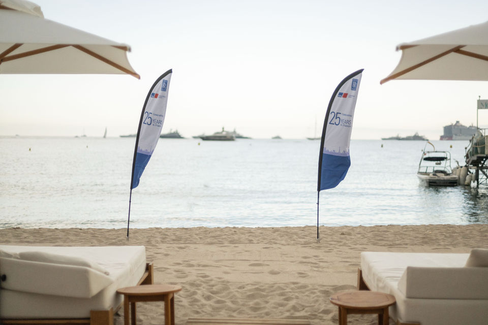 Beach flag publicitaire personnalisé installé sur la plage, avec impression grand format résistante aux conditions extérieures pour la communication événementielle.