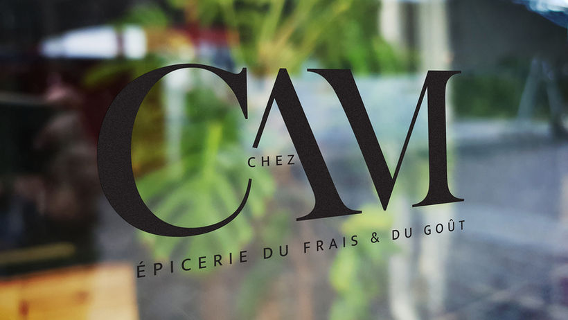 Sticker en lettres découpées noires appliqué sur la vitrine d’une boutique.