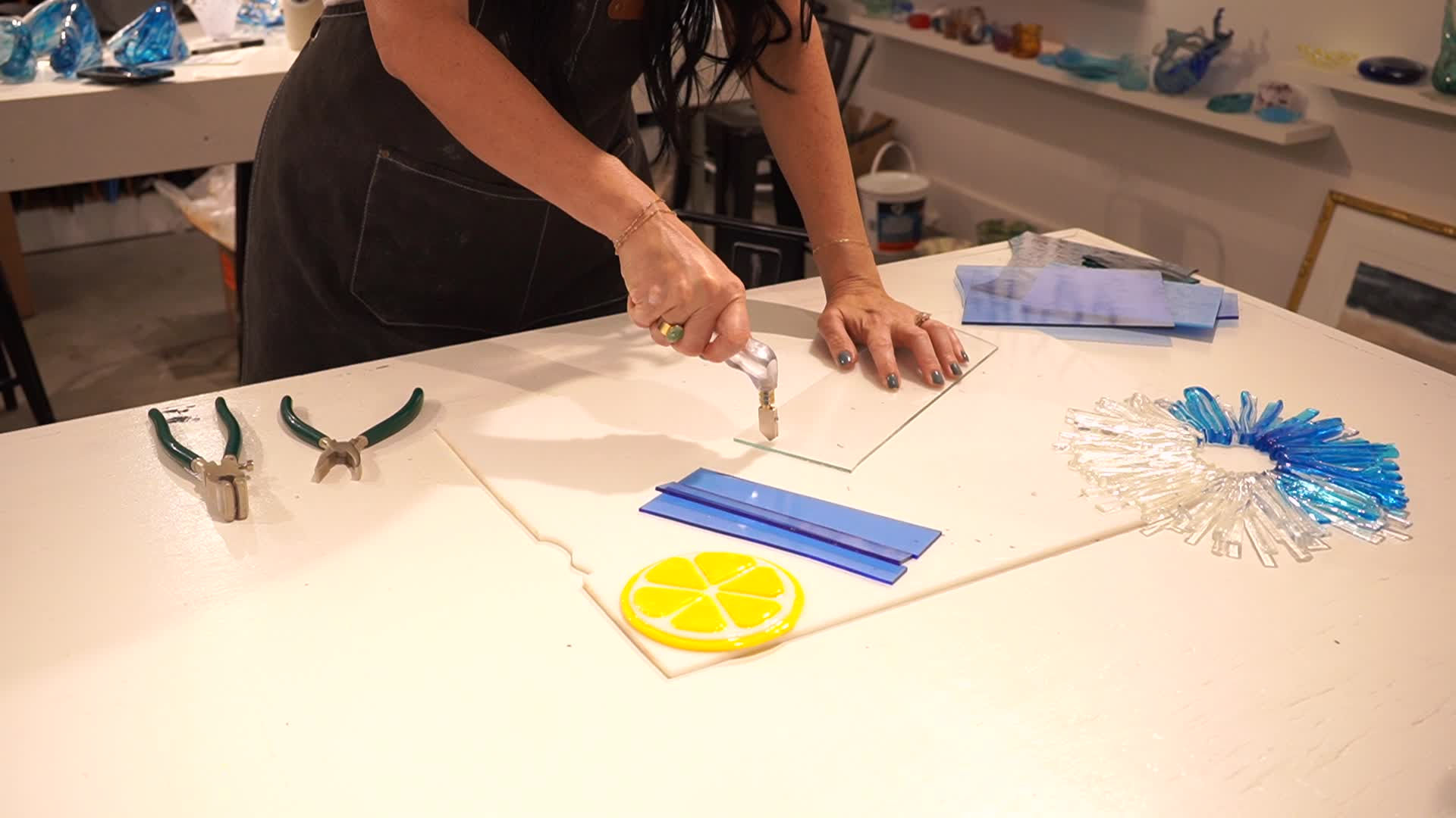 Scoring glass with a cutter during a hands-on Glass Deer fusing class