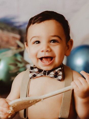 calgary-cake-smash-photography-boy-holds-spoon-smiling