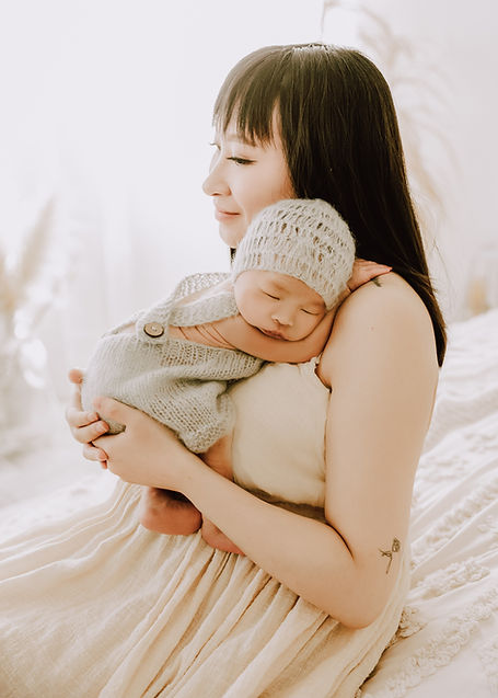 Calgary-newborn-photography-mom-holds-newborn-over-shoulder