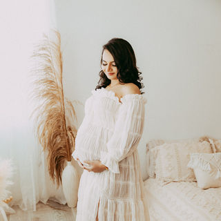 Calgary-maternity-photography-woma-holds-belly-by-window