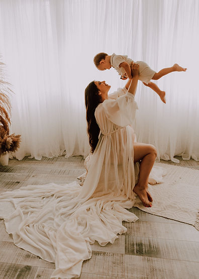 calgary-maternity-photography-with-mom-holding-older-sibling-in-the-air