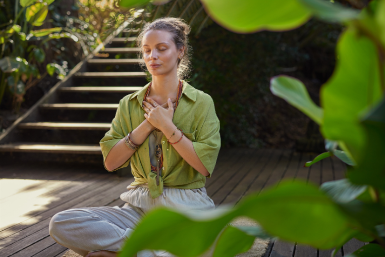 Amidst the lush greenery of Bali, a woman finds tranquility in meditation.