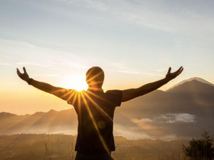 Silhouette of person with arms raised at sunrise in Bali, symbolising hope, neurological healing, and recovery from addiction at Holistic Recovery Bali